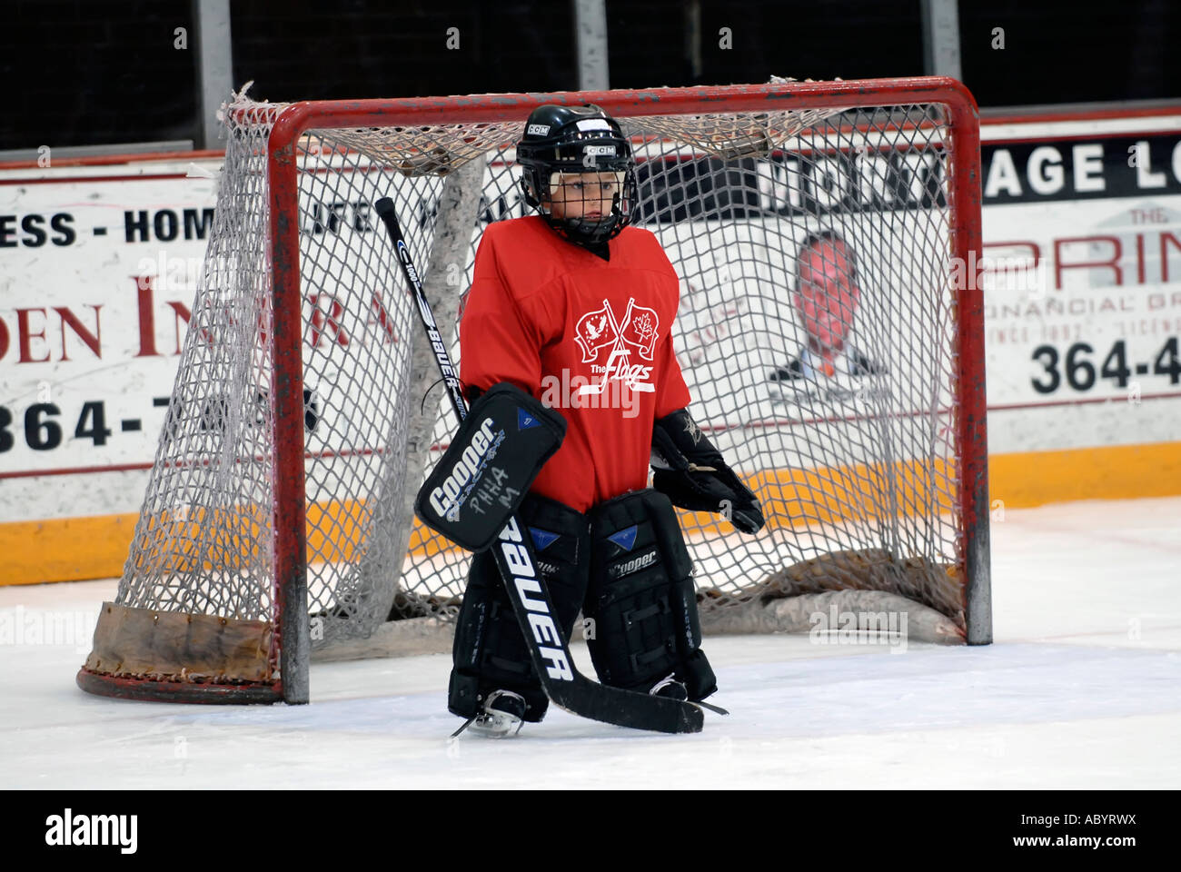 6 anno vecchio ragazzo riproduce la posizione del portiere in un teenager hockey su ghiaccio programma Foto Stock
