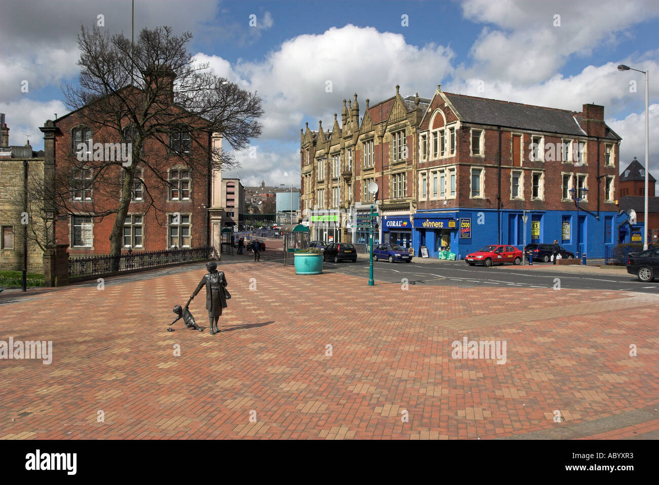 La scultura moderna di madre e bambino giocattolo in Blackburn centro storico di fronte alla cattedrale Foto Stock