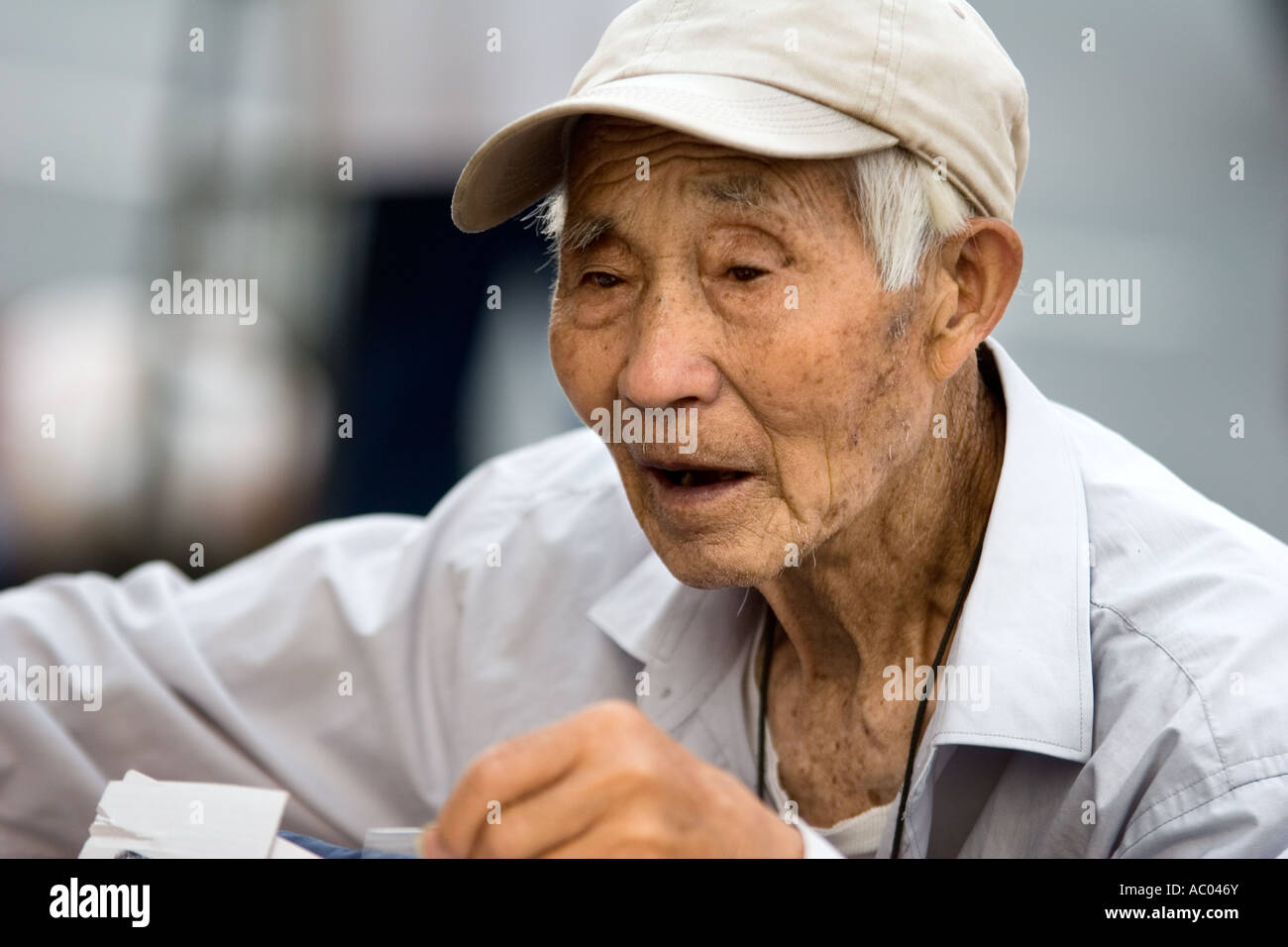 Un anziano Asian venditore ambulante in Chinatown, la città di New York, New York. Candide foto. Foto Stock