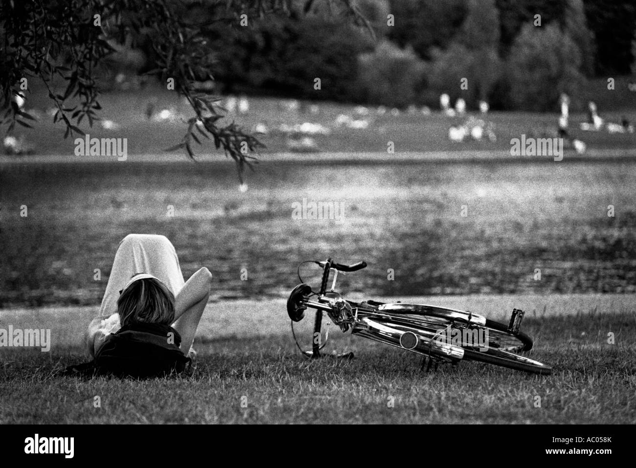 Londra. Una ragazza la posa in prossimità di un parco lago Foto Stock