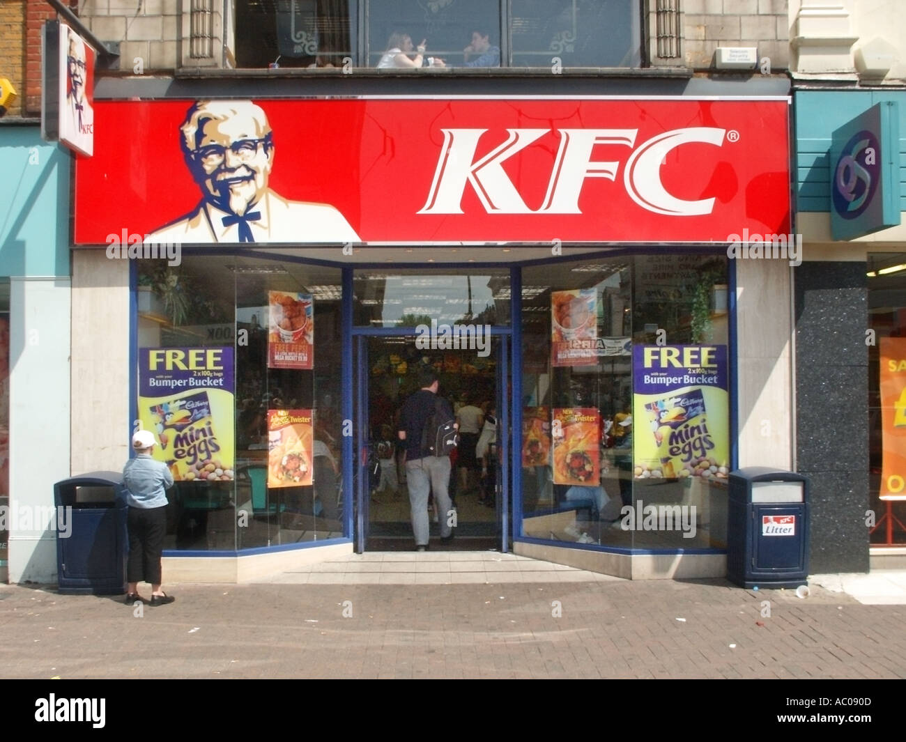 Southend on Sea seaside resort accanto al fiume Thames Estuary youngster guardando poster vetrina High Street KFC shop Foto Stock