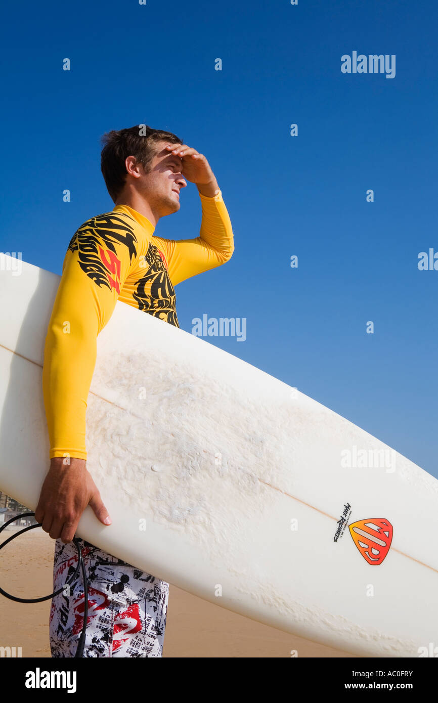 Un surfista si affaccia alle onde a Manly Beach a Sydney s North Shore Foto Stock