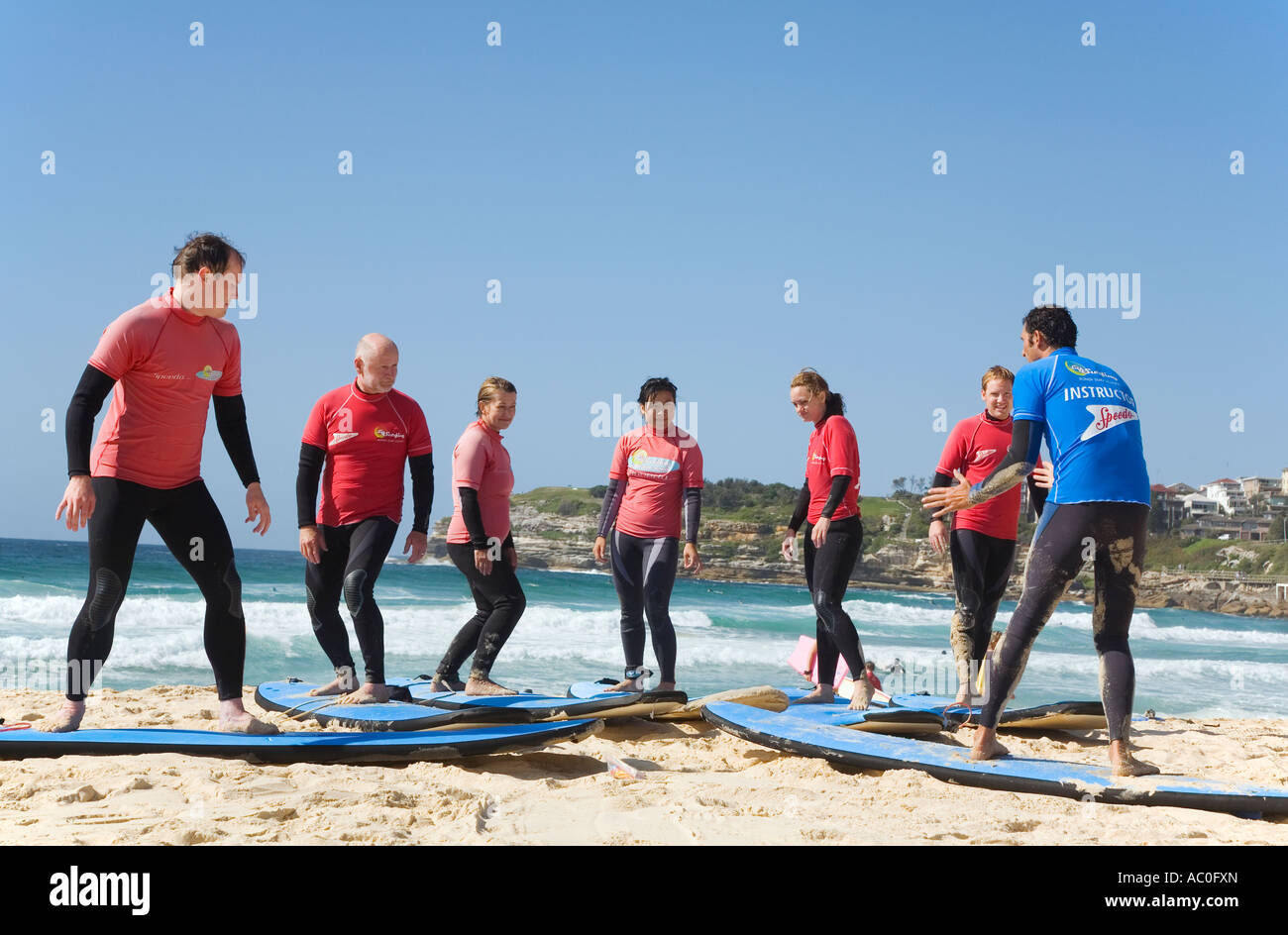 Gli studenti ottengono lezioni di surf sulla spiaggia prima di colpire le onde a Bondi Beach a Sydney Foto Stock