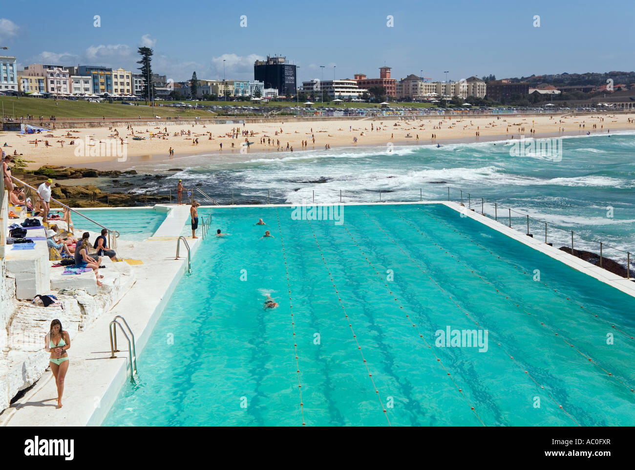 I visitatori prendere il sole e rilassarsi presso il Bagni di Bondi ocean pool riempito all'estremità meridionale di Bondi Beach Foto Stock