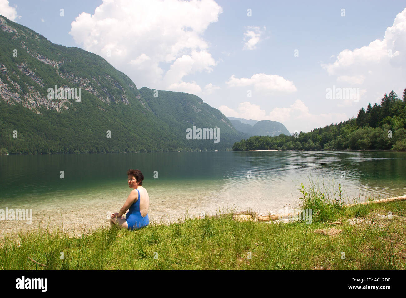 Donna seduta al lato del lago di Bohinj Slovenia Foto Stock