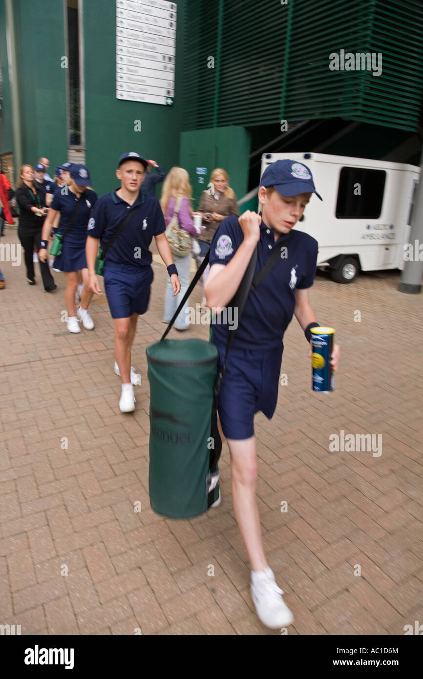 La linea della sfera ragazzi a piedi per una partita a tennis di Wimbledon campionati UK Foto Stock