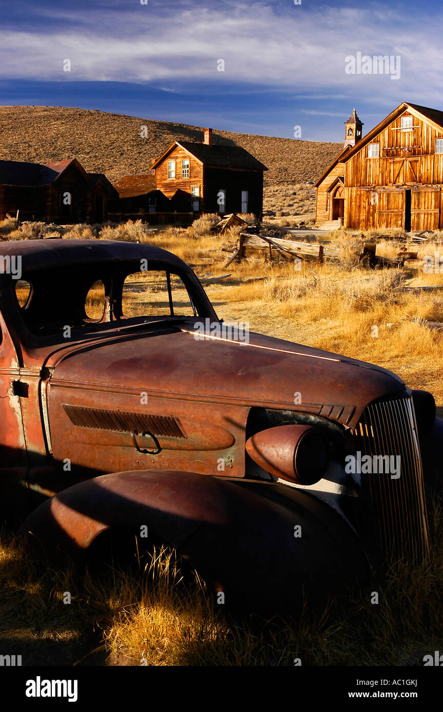 Vecchia auto di fronte fienili abbandonati ed edifici Foto Stock