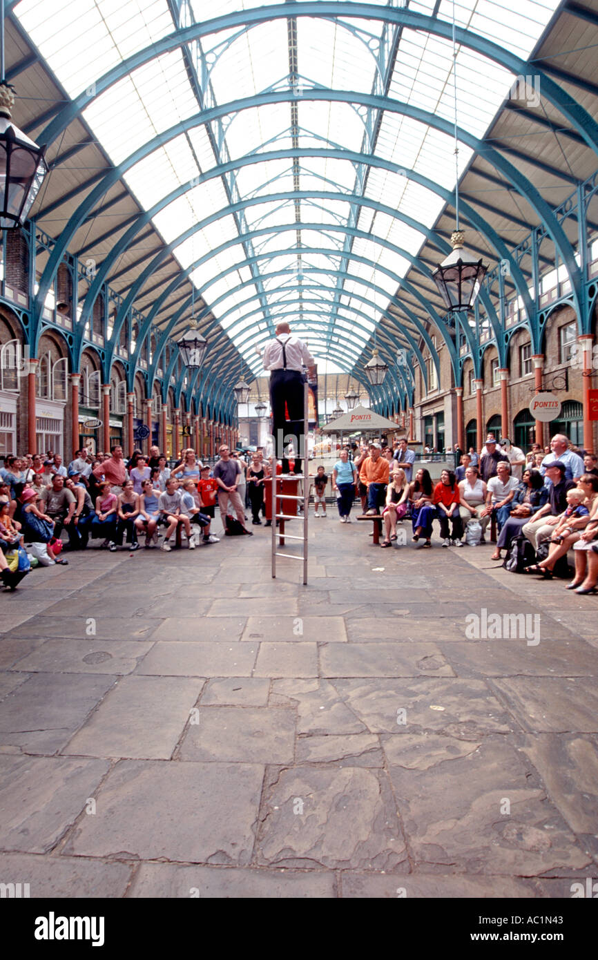 Un suonatore ambulante di eseguire all'interno del mercato di Covent Garden nel west end di Londra. Foto Stock