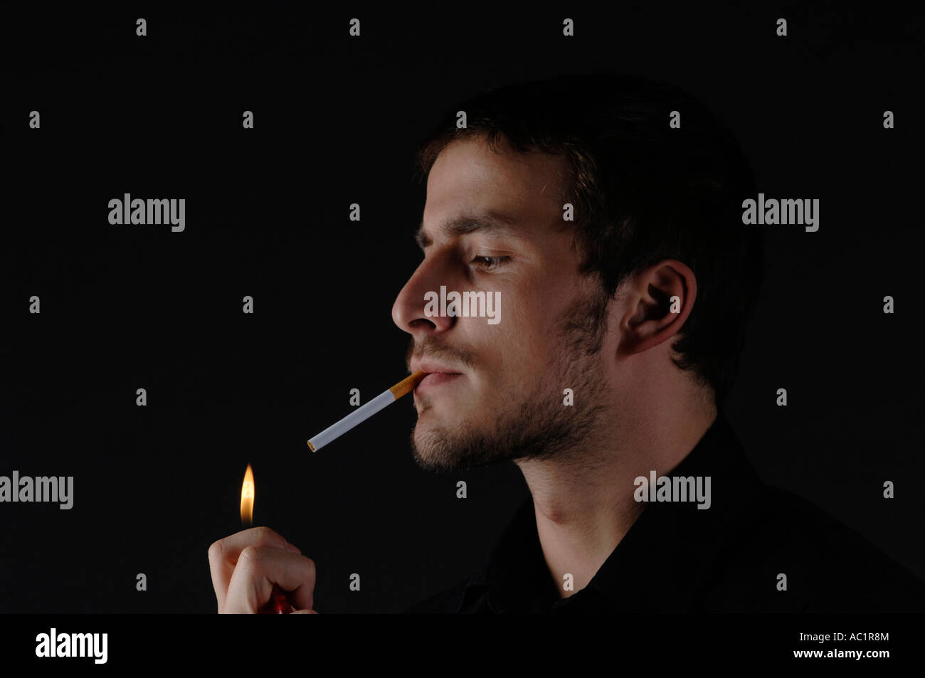 L'uomo accendere una sigaretta, ritratto Foto Stock