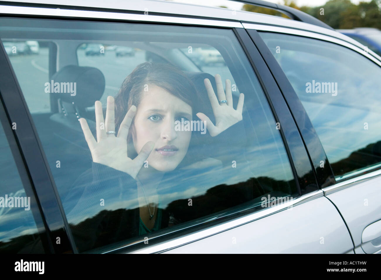 Giovane donna seduta in auto Foto Stock