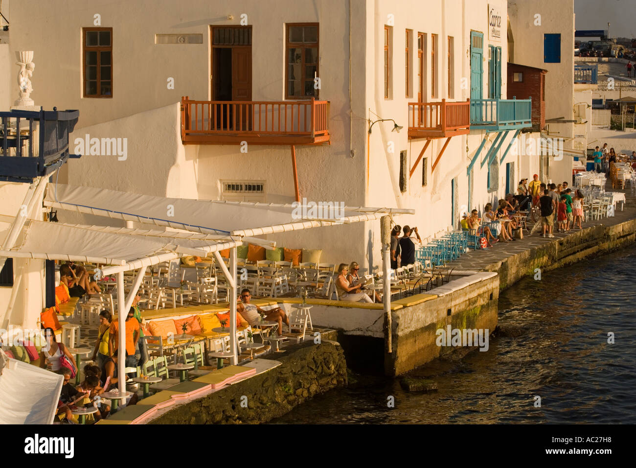 La gente seduta nel ristorante direttamente in mare la piccola Venezia città di Mykonos Mykonos Grecia Foto Stock