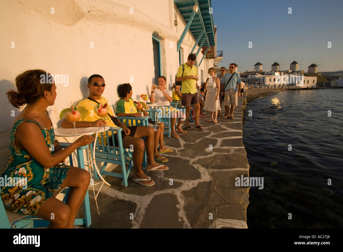 La gente seduta in Caprice Bar direttamente in mare la piccola Venezia città di Mykonos Mykonos Grecia Foto Stock