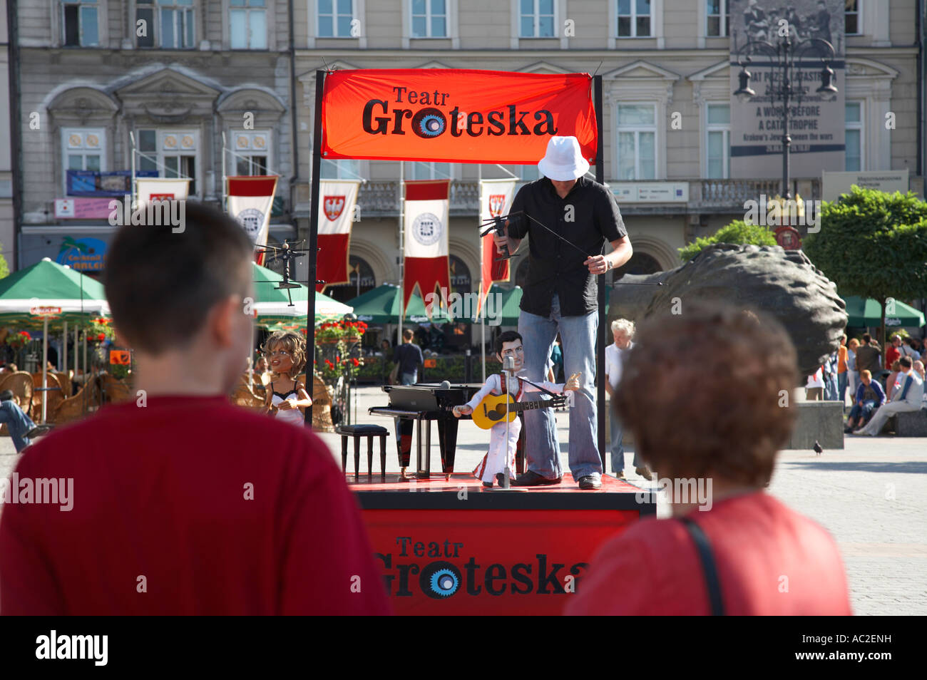I turisti a guardare le prestazioni di street Puppet Theatre Rynek Glowny piazza della città di Cracovia Foto Stock