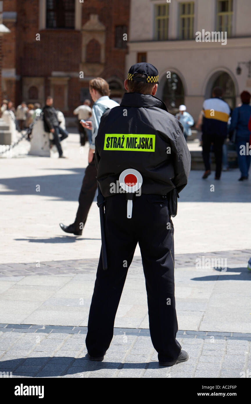 Officer in polacco della polizia municipale di guardare la permanente di pattuglia in Rynek Glowny piazza della città di Cracovia Foto Stock