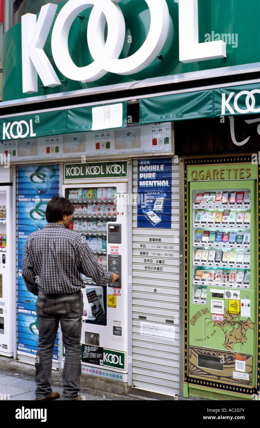 Novembre 2, 2004 - uomo acquista un pacchetto di sigarette da un distributore automatico a Tokyo di Shibuya. Foto Stock