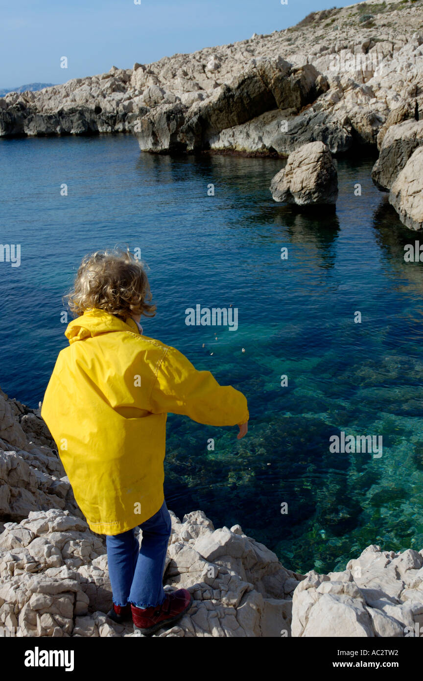 Francia marseille vicino a Les goudes village la calanque du trou bambina gettare sassi in acqua Foto Stock