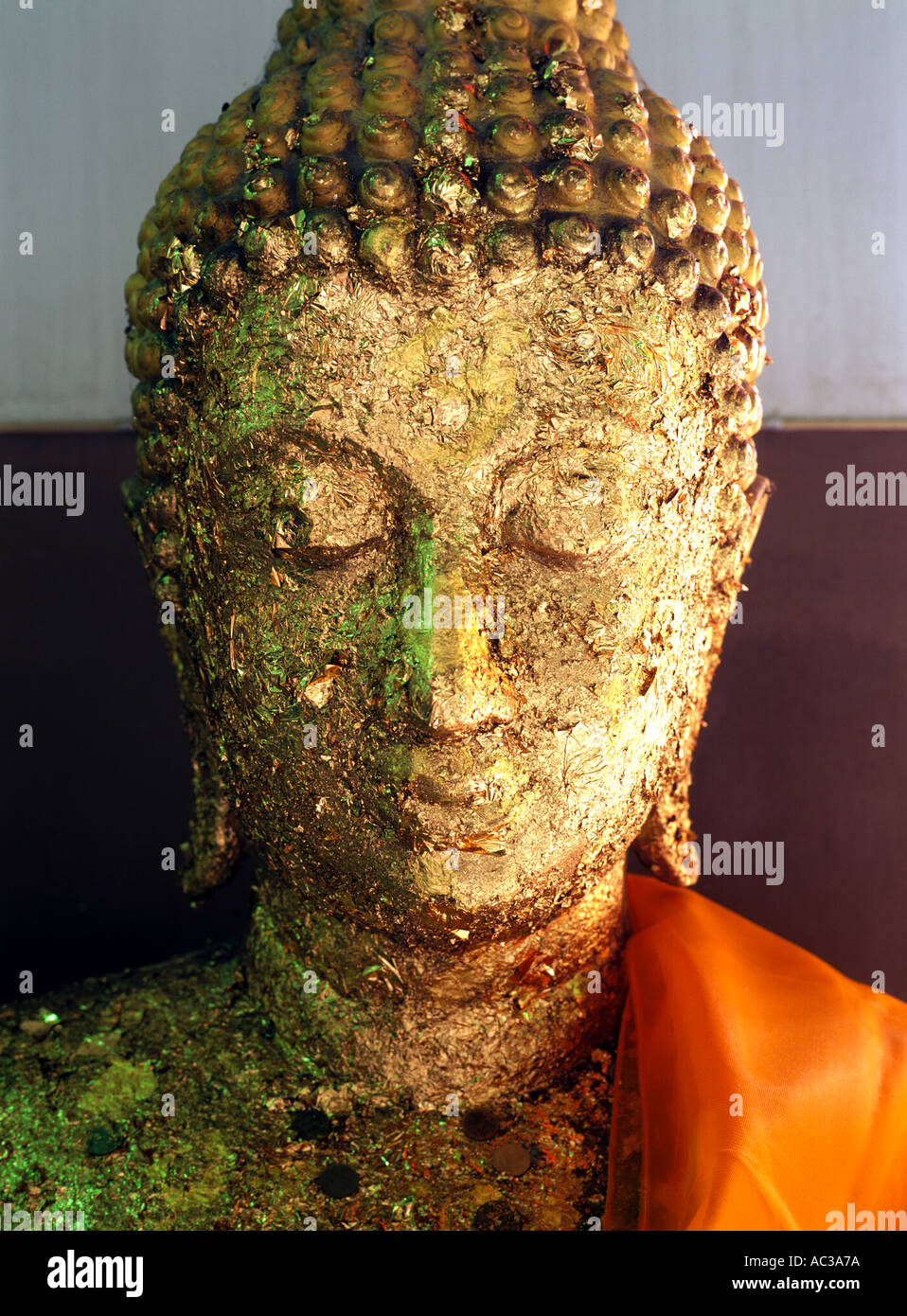 Un Thai statua del Buddha ricoperta in foglia oro dai visitatori del tempio a Bangkok, in Thailandia Foto Stock