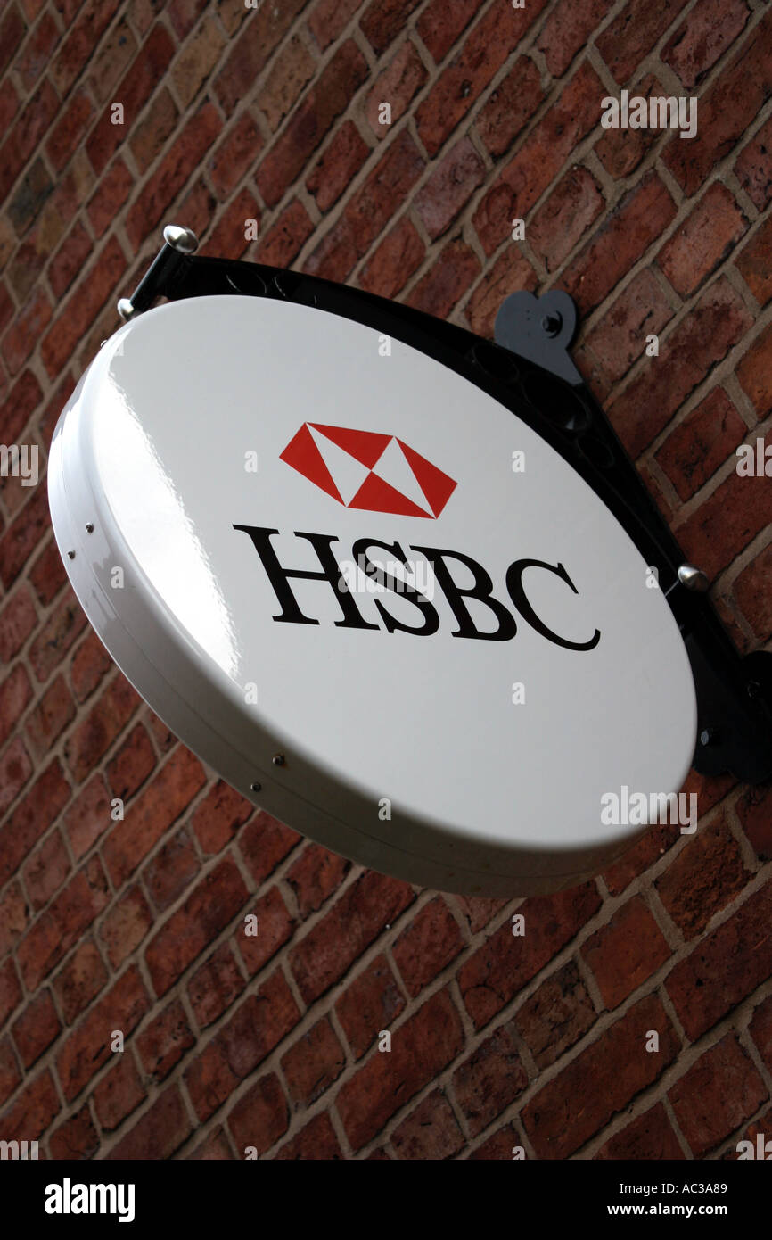 HSBC banking segno log e appeso a una parete appendiabiti collegato ad una parete di mattoni su una banca di Chester, Cheshire, Regno Unito Foto Stock