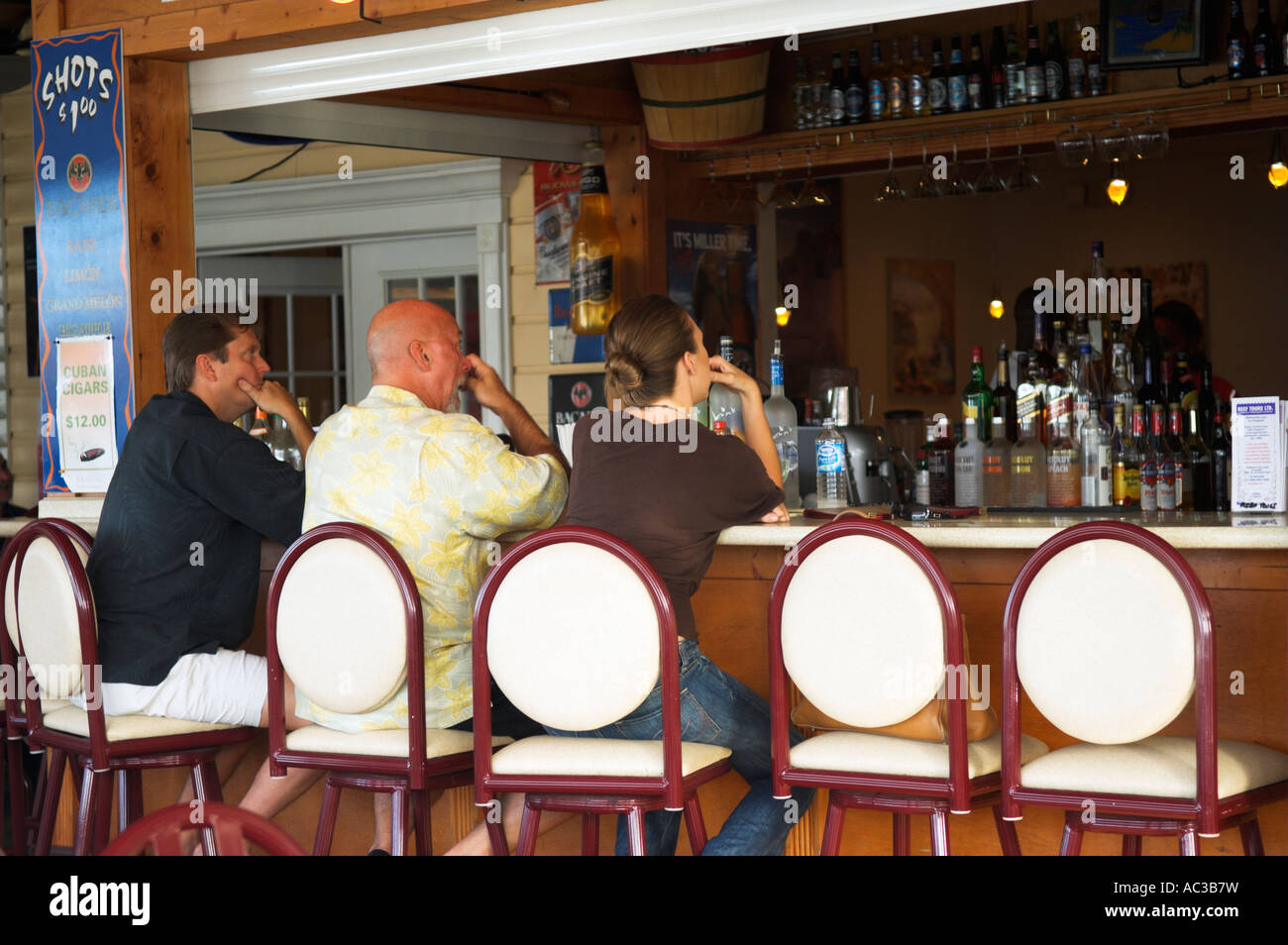Tre persone cinque sgabelli al bar Le Med Port Lucaya Grand Bahama Foto Stock