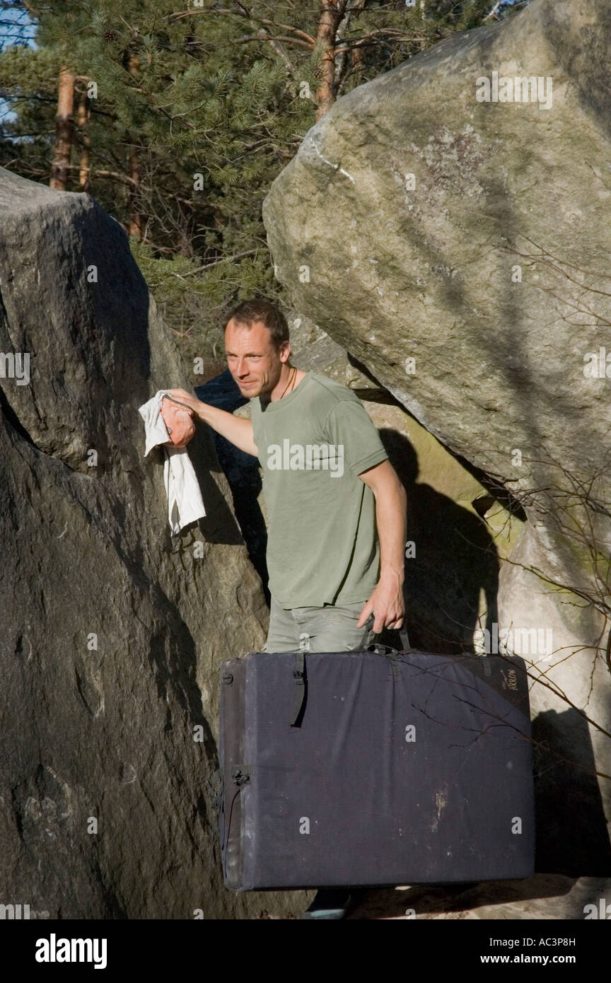 Boulderer camminare con il bouldering mat e pof a Fontainebleau Francia Foto Stock