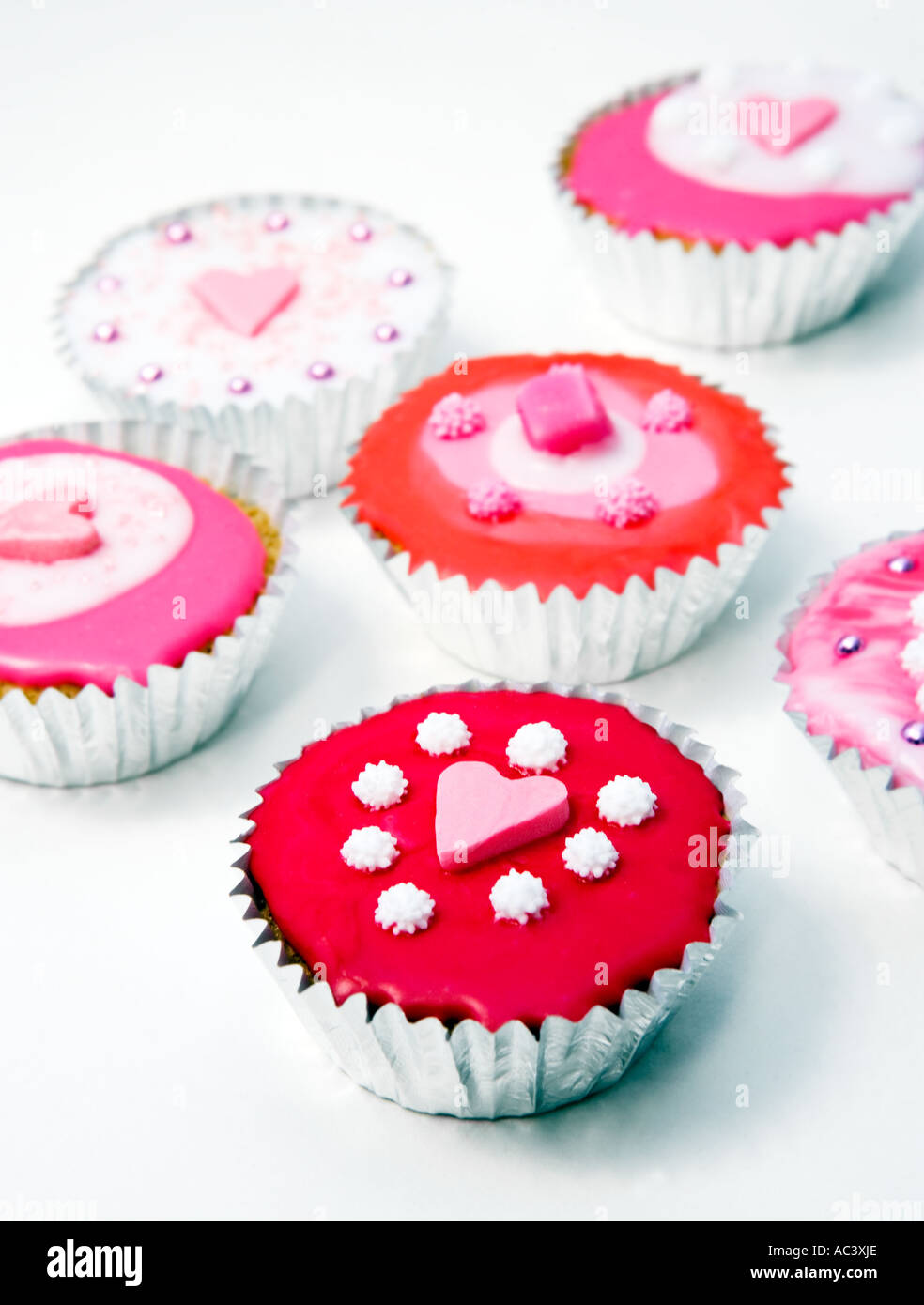 Fatto in casa Torte cup - torte a base di pan di spagna ghiacciate e decorate con glassa di colore rosa. Foto Stock