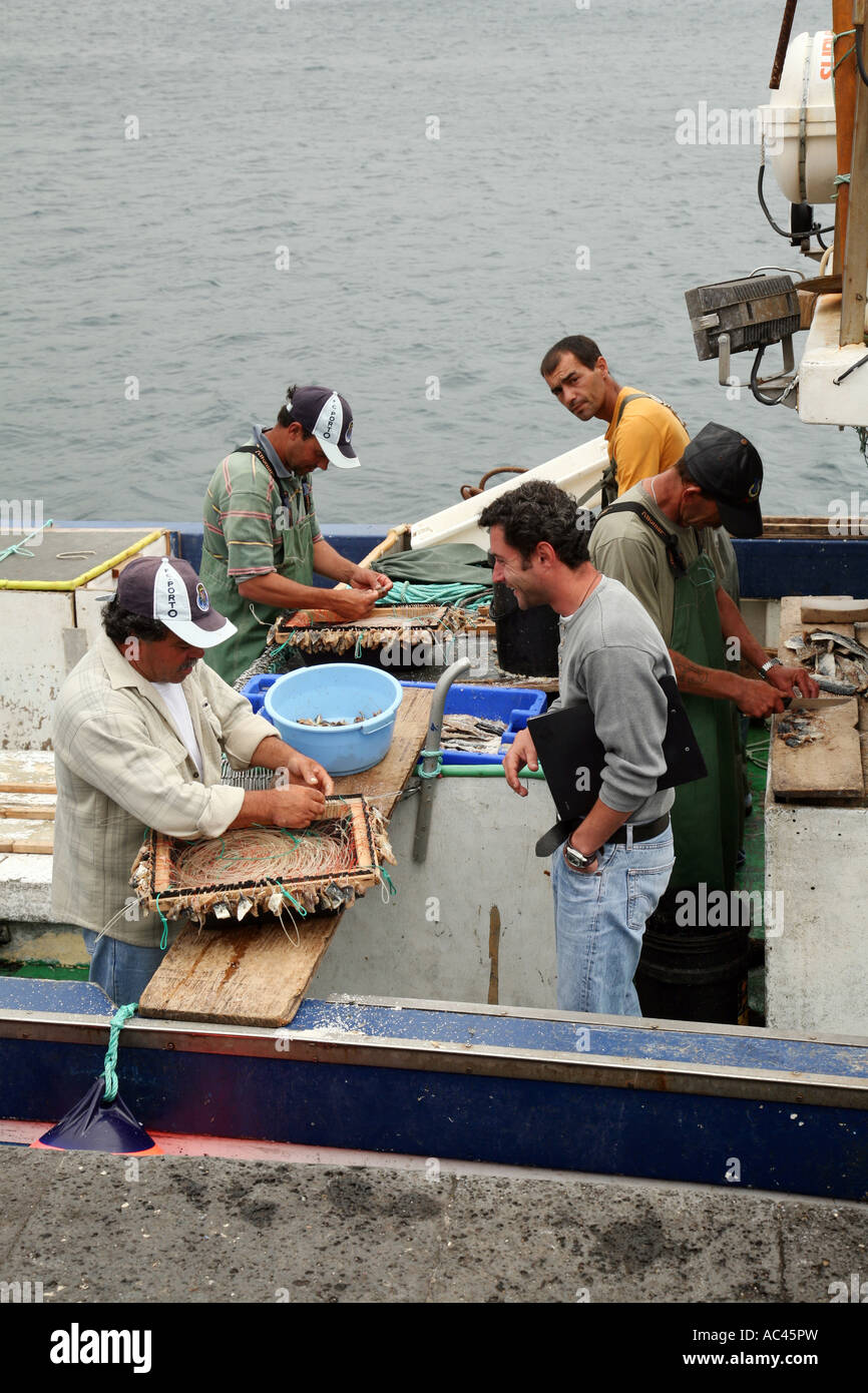 I pescatori locali a lavorare a bordo della loro barca a strascico, porto di Horta, Faial, Isole Azzorre Foto Stock