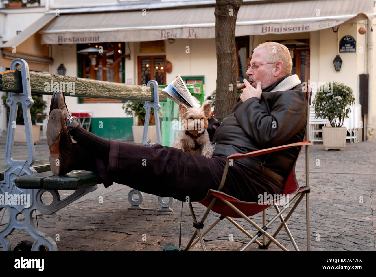 Uomo di fumare il sigaro in Paris Square con piccoli terrier al giro Foto Stock
