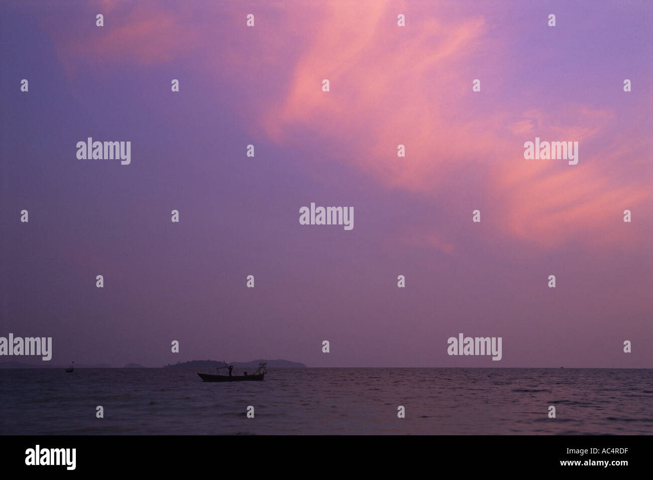 La pesca sotto un viola e rosa tramonto al largo della costa della Cambogia Foto Stock