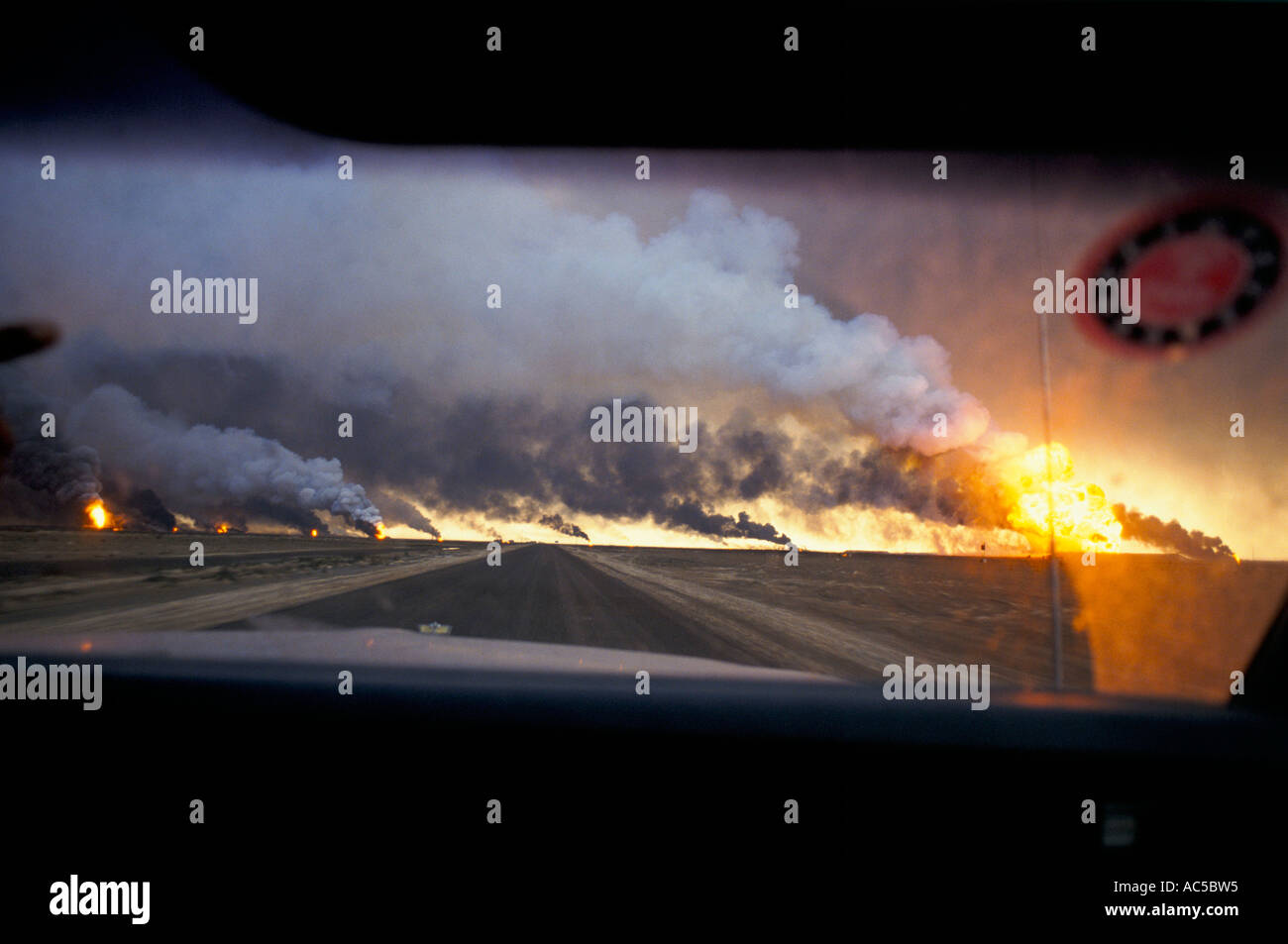 KUWAIT LACERATO DALLA GUERRA vista orizzontale per la combustione di olio campi nel deserto DA MACCHINA KUWAIT APRILE 1991 Foto Stock