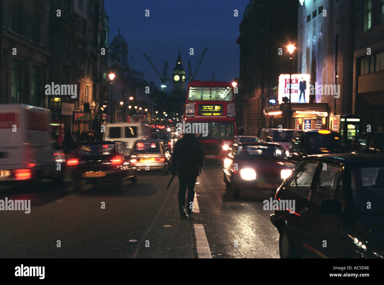 Uomo che cammina nel mezzo della strada Piccadilly Circus Londra Foto Stock