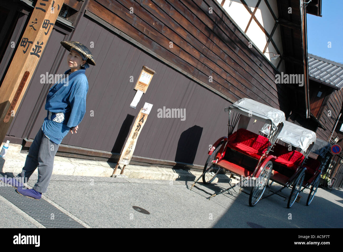 Un rickshaw driver femminile attende i clienti nella San machi Suji trimestre, Takayama Giappone Foto Stock