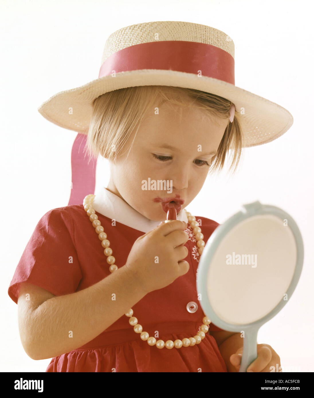 Piccola ragazza sperimentando con il rossetto e vestirsi Foto Stock