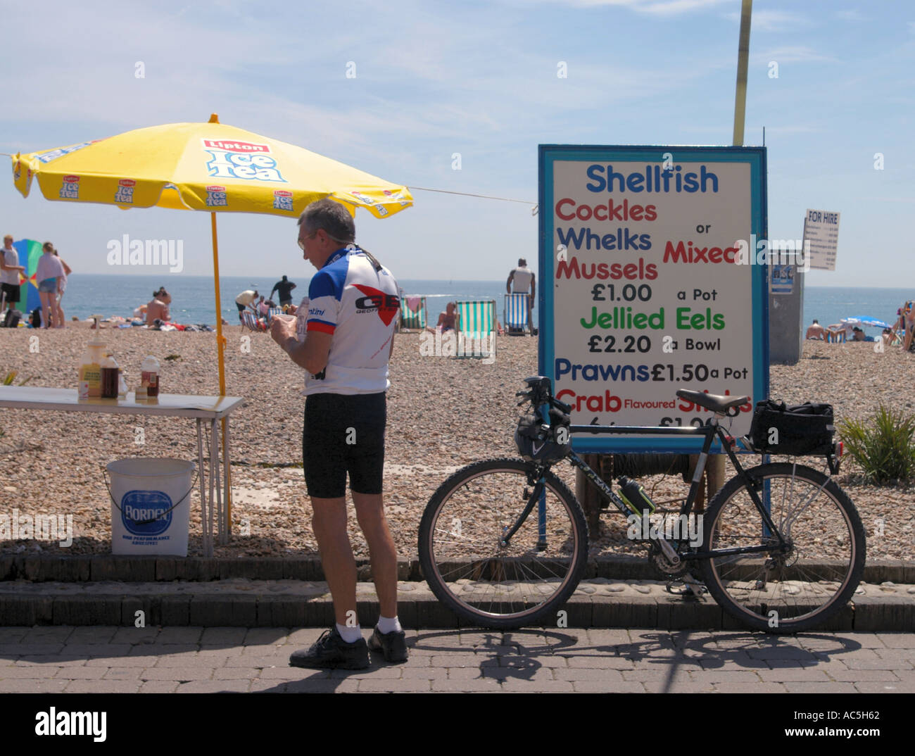 Un ciclista cerca alcuni frutti di mare sulla spiaggia di Brighton Foto Stock