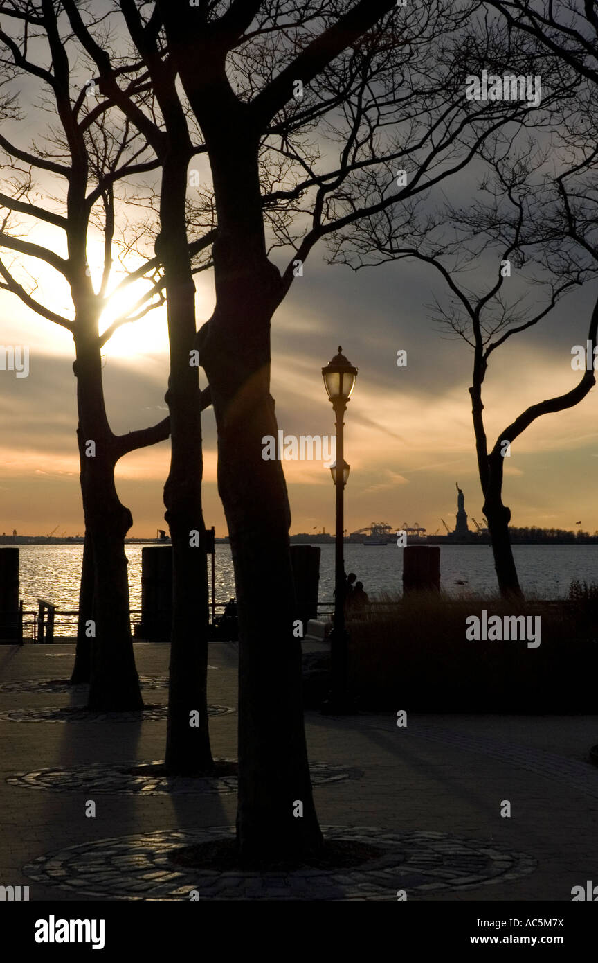 Battery Park al tramonto guardando fuori per la Statua della Libertà. Foto Stock