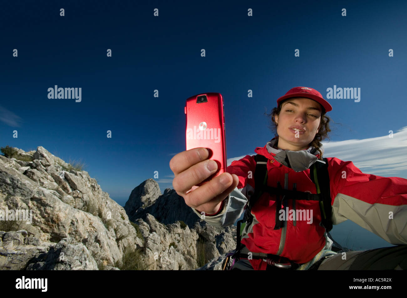 Donna di scattare una foto su un rosso telefono con fotocamera in montagna Foto Stock