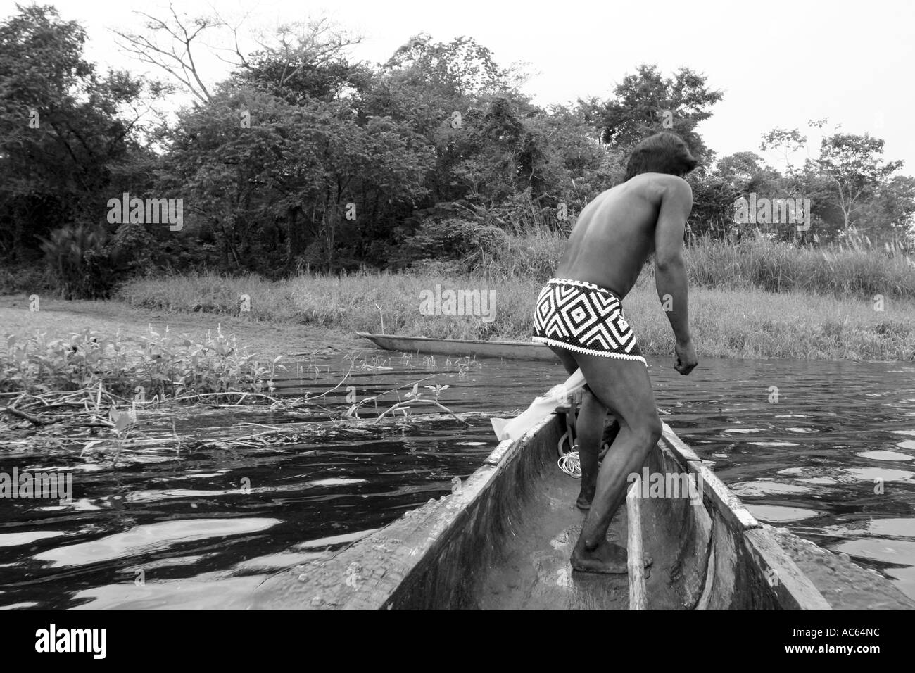 Un Embera indian vela attraverso il Fiume Chagres nella giungla Panamenian Chagres il parco nazionale nella sua canoa Foto Stock