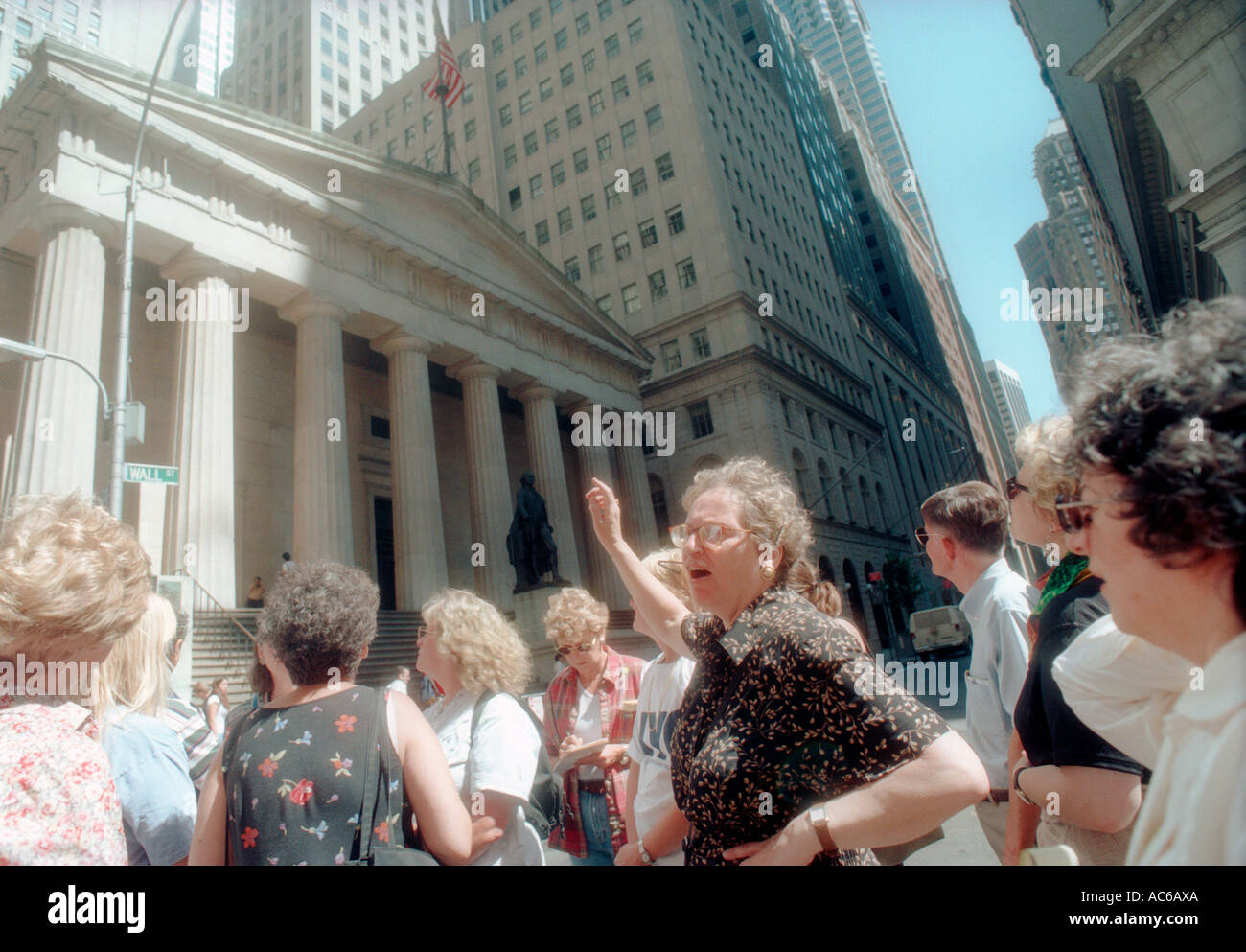 Un tour a piedi si ferma di fronte a Federal Hall National Memorial presso l'angolo di ampia e Nassau strade di Lower Manhattan Foto Stock