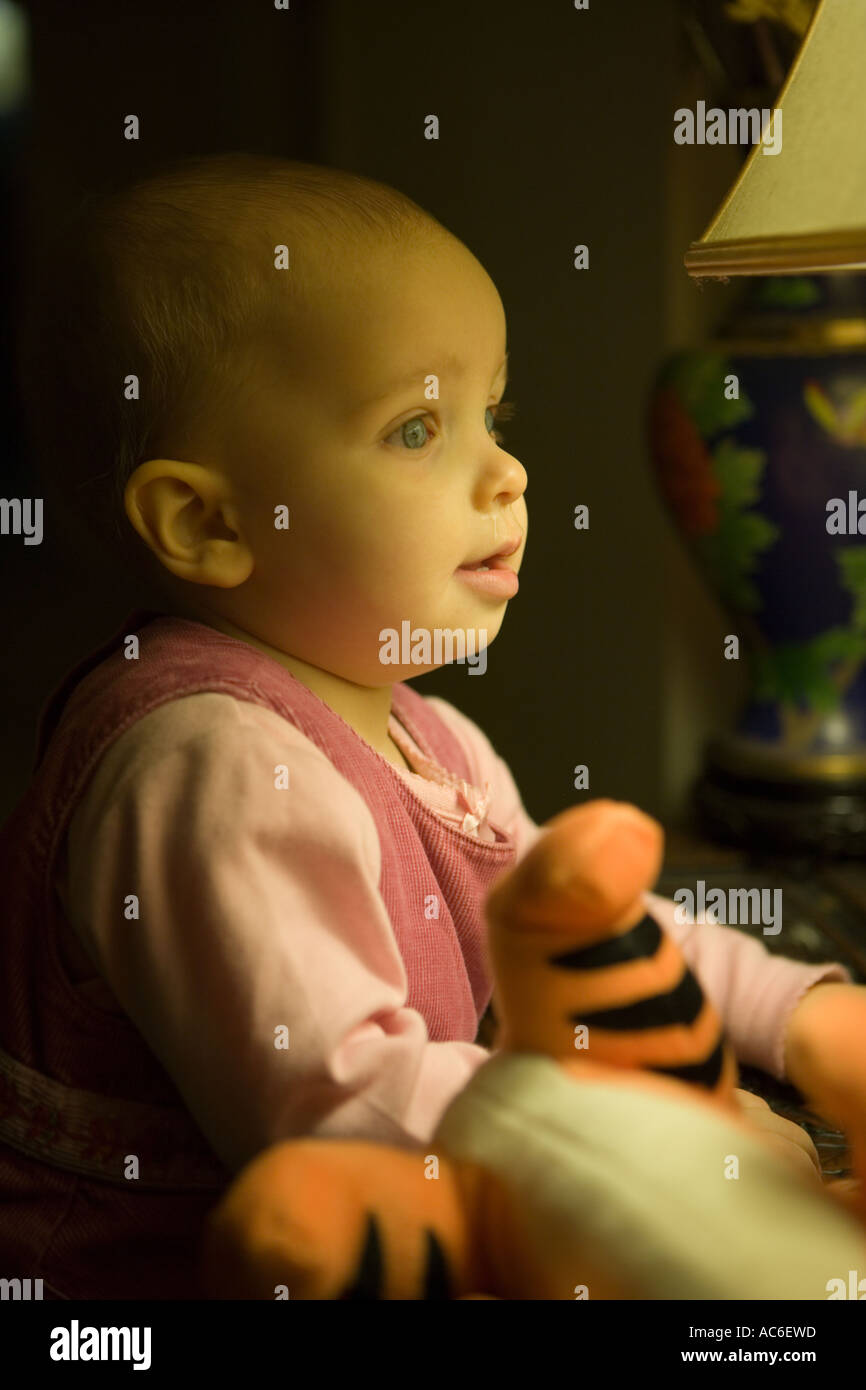 Bambina con naso che cola guarda nella lampada Foto Stock