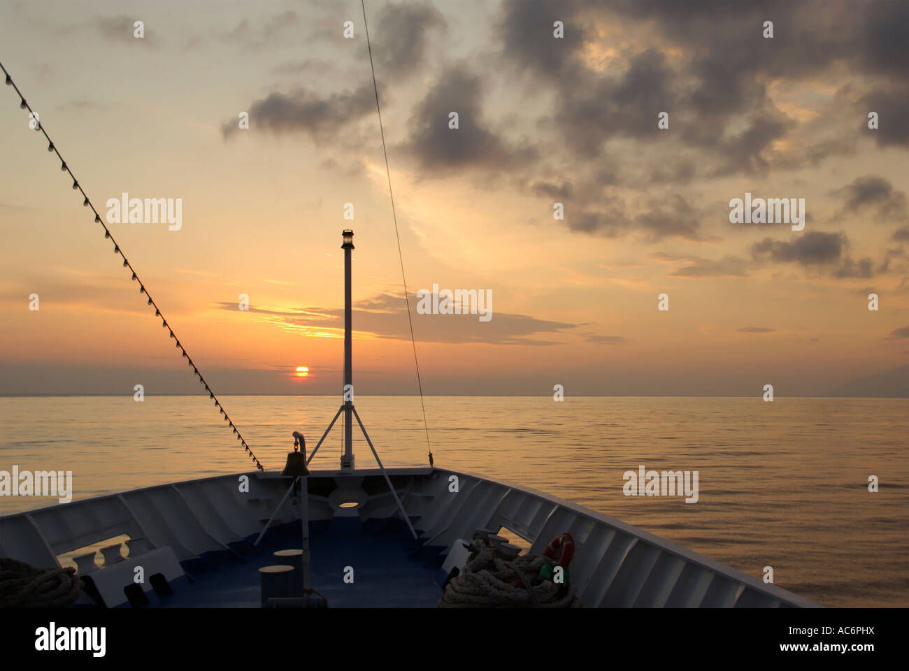 Tramonto al mare Ionio cali di Sun verso l'orizzonte come visto dalla prua di una nave da crociera Foto Stock