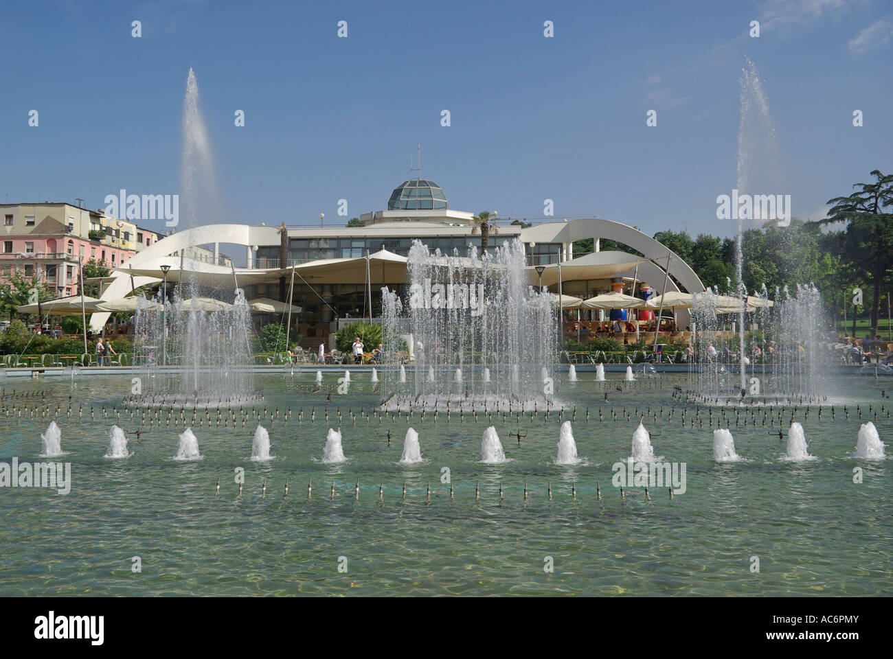 Tirana Repubblica di Albania funzione acqua & display fontana al centro di Taiwan ristorante complesso persone seduti all'aperto all'ombra di bianchi ombrelloni da sole Foto Stock
