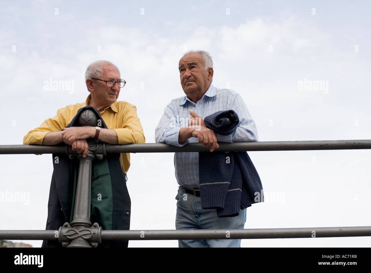 Due locali gli uomini italiani chiacchierando sul lato della banchina di Amalfi in Italia Foto Stock