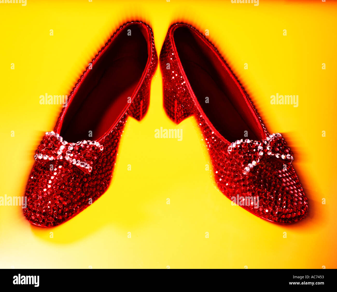 Rosso rubino pantofole con archi su sfondo giallo Foto Stock