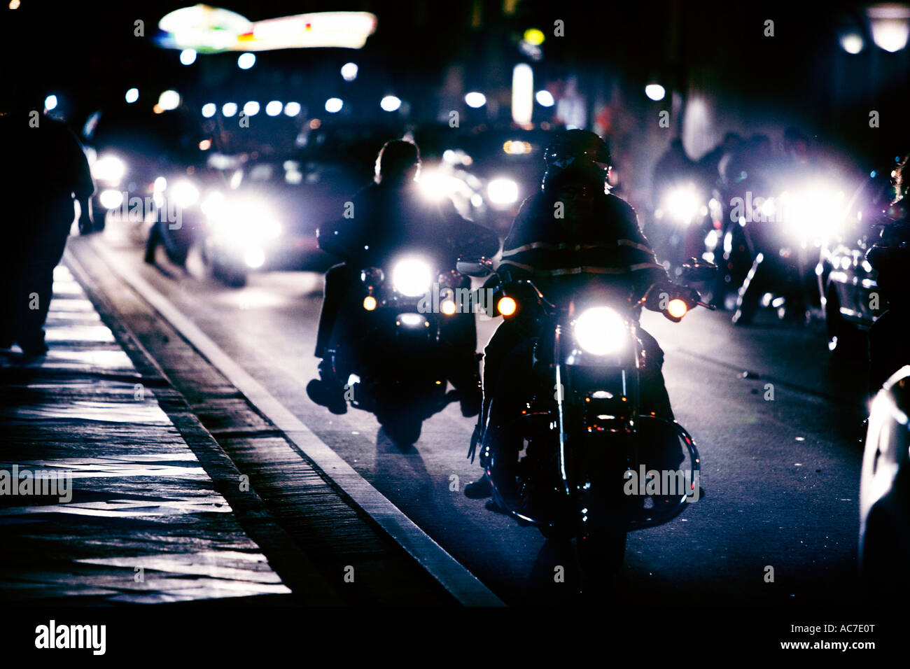 Grande gruppo di motociclisti per strada di notte Foto Stock