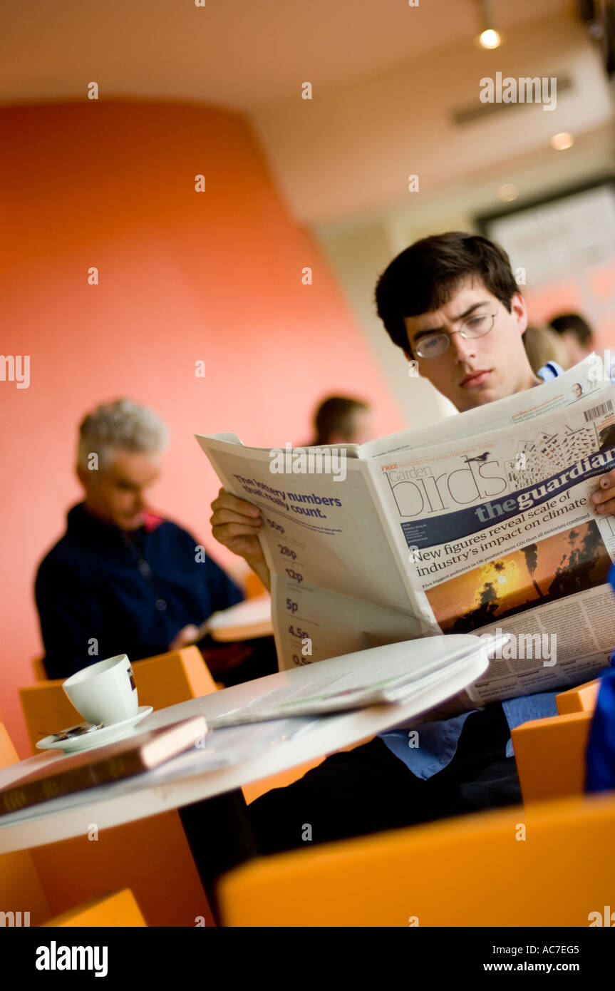 L'uomo leggendo il quotidiano The Guardian in Aberystwyth Arts Centre Cafe Foto Stock