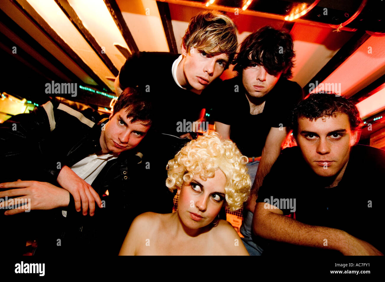 Aberystwyth studente pop band gli incantesimi in una squallida bar - cantante donna che indossa una bionda parrucca ricci Foto Stock