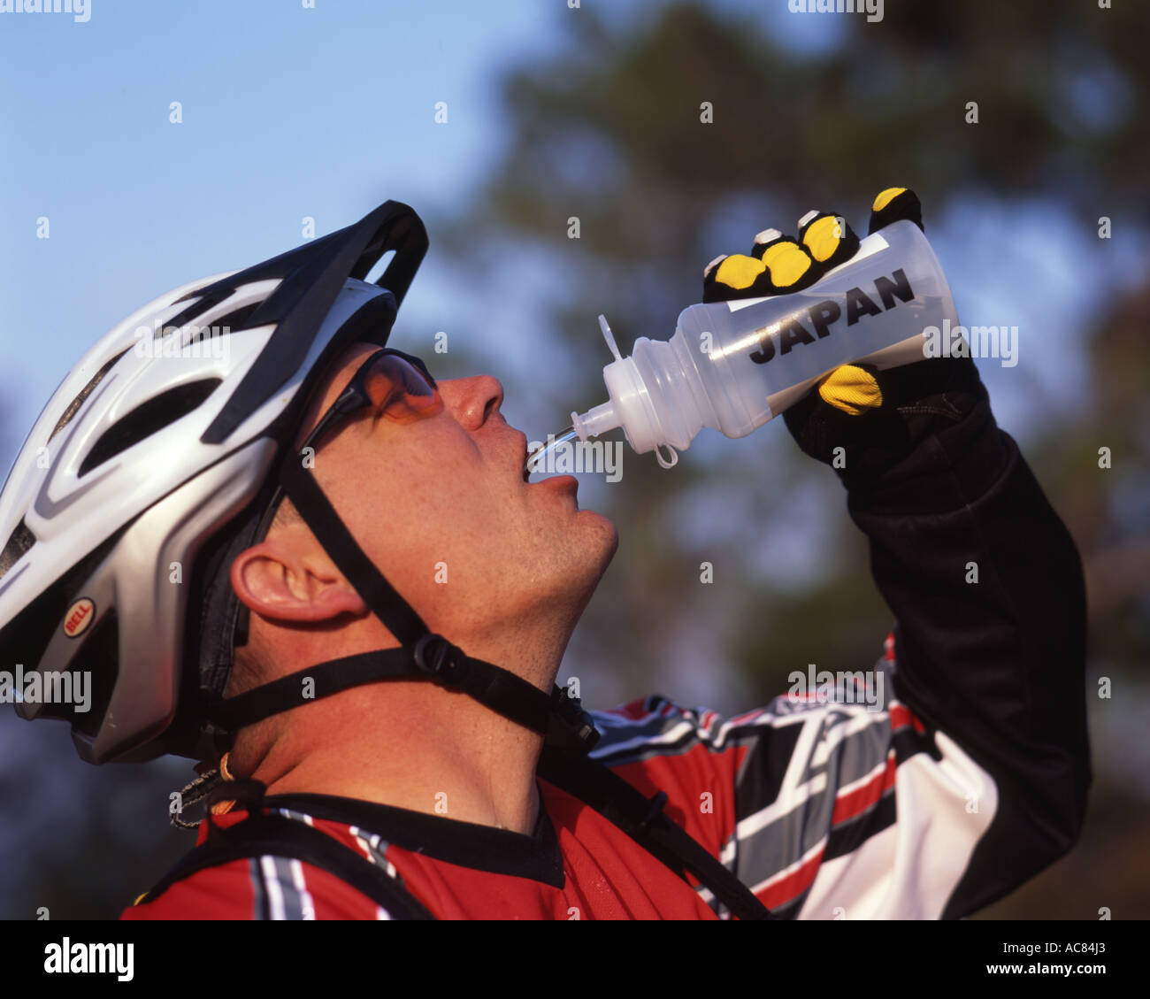 Mountain Biker bere da waterbottle mentre in sella a Okinawa, Giappone Foto Stock
