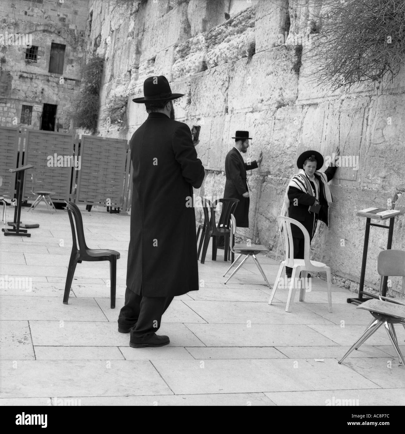 La tradizione incontra la tecnologia un Hassid e suo figlio pregare e pongono al santissimo sito in Israele Muro Occidentale di Gerusalemme Israele Foto Stock