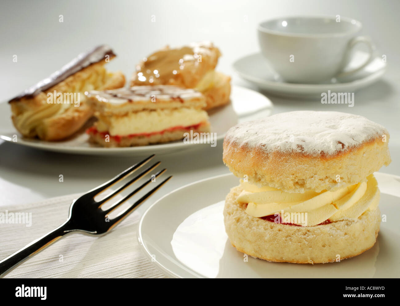 Fresche fatte a mano delle torte di panna servita su bianco stoviglie con tazza e piattino Foto Stock