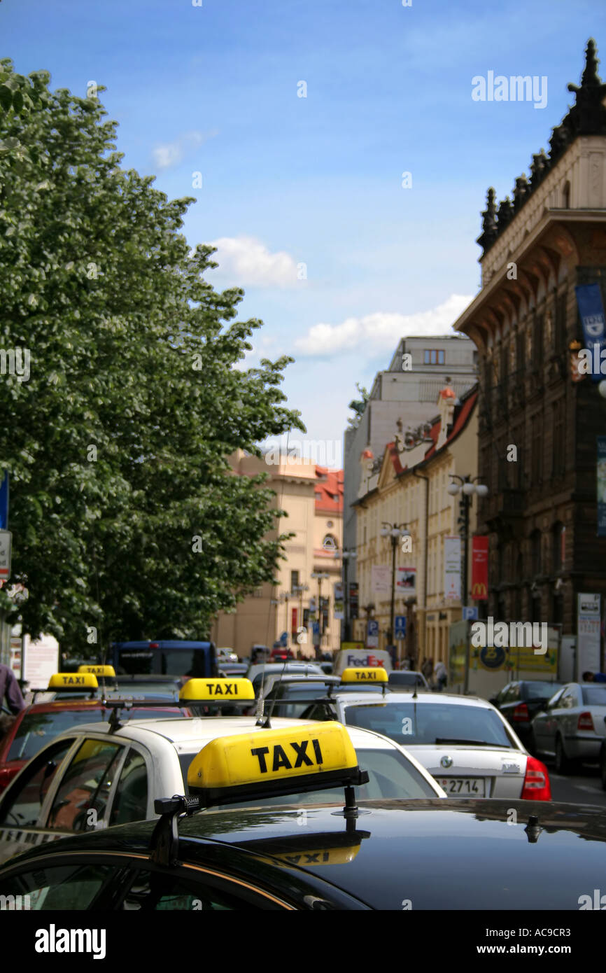 Taxi allineati lungo una vivace strada urbana con architettura storica. Foto Stock