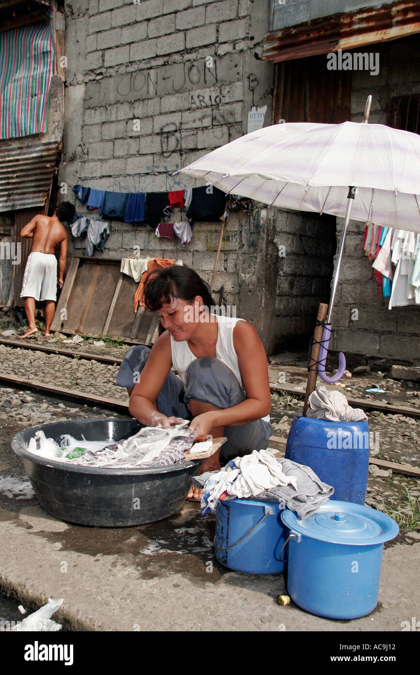 Servizio lavanderia dai binari ferroviari nella baraccopoli di Manila Foto Stock